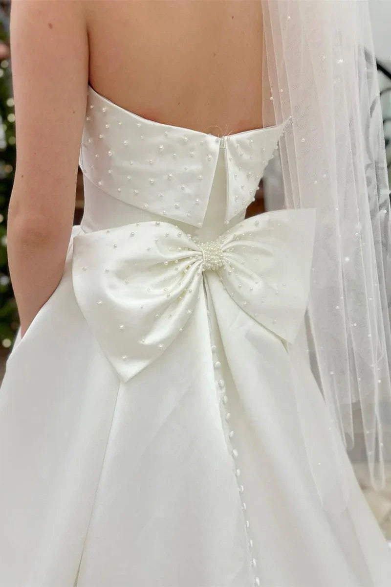 Strapless Satin Wedding Dresses with Pearl Embellishments, Oversized Back Bow, Side Pockets and Voluminous A-Line Skirt Bridal Gown
